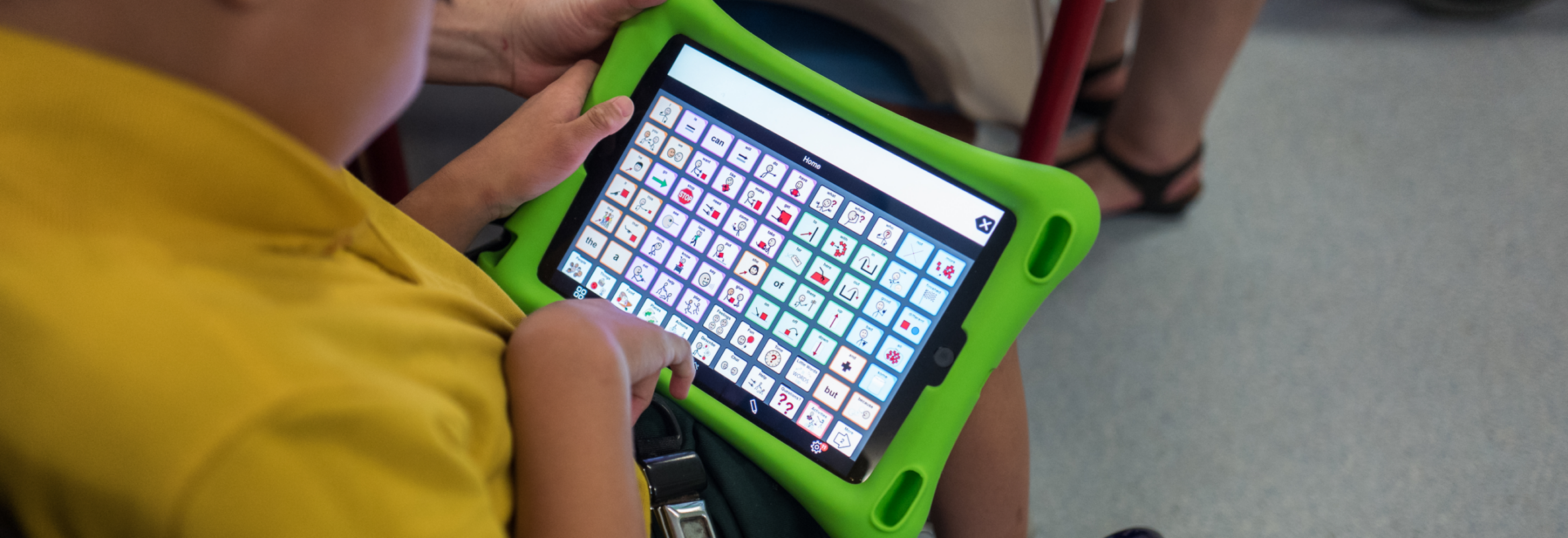 Photo en gros plan d'un garçon tenant un iPad avec Proloquo2Go